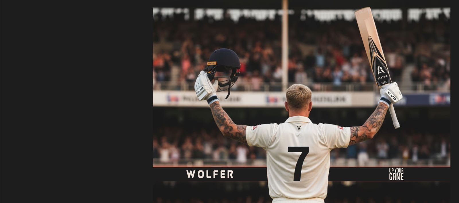 Cricketer raising a Wolfer cricket bat and helmet to a cheering crowd